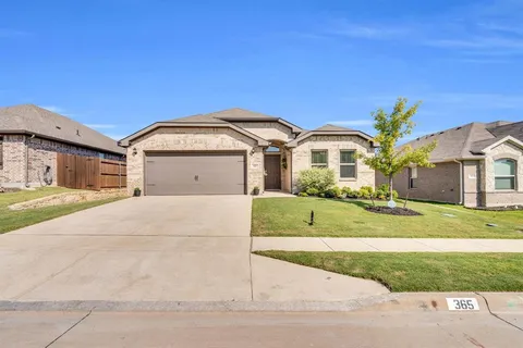 a front view of a house with a garden and yard