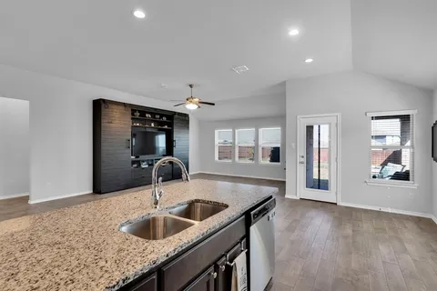 a kitchen with granite countertop a sink and refrigerator