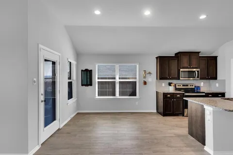 a view of a kitchen with a sink a refrigerator and window