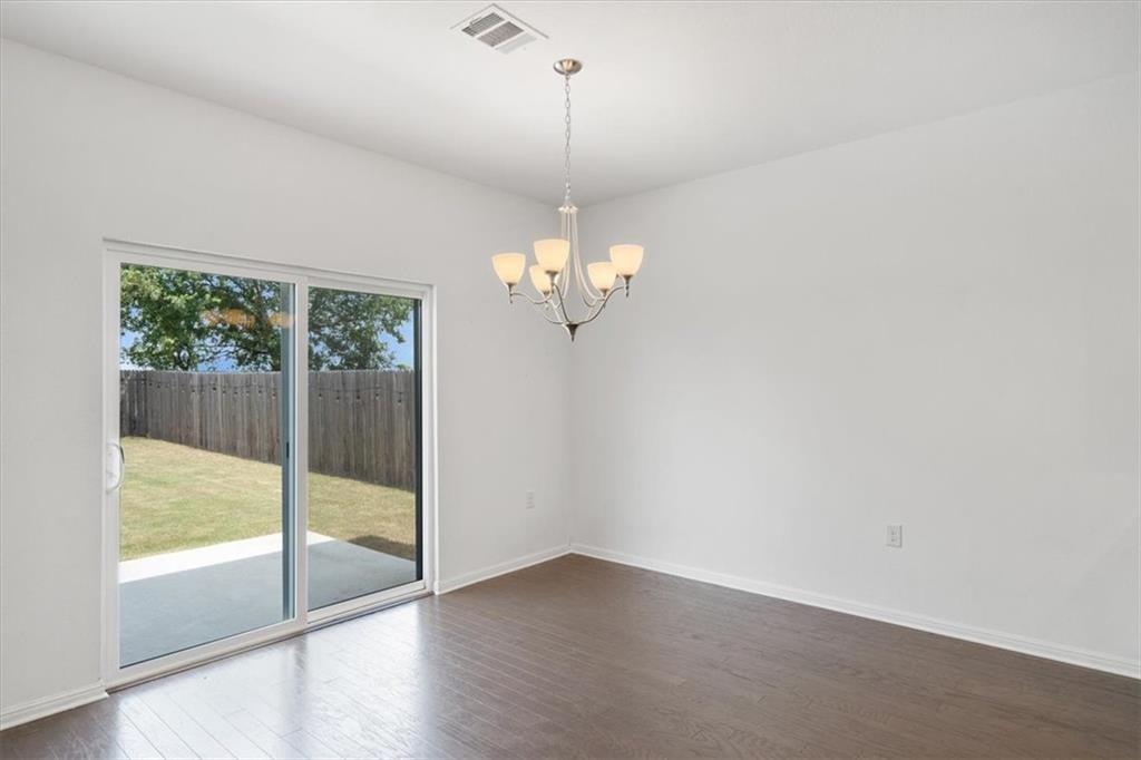 6500 Routenburn Street Austin, TX 78754 - Photo 12 of 38 Spare room with a chandelier and dark wood finished floors