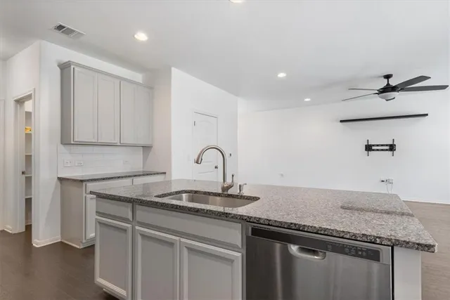 a kitchen with granite countertop a sink and cabinets