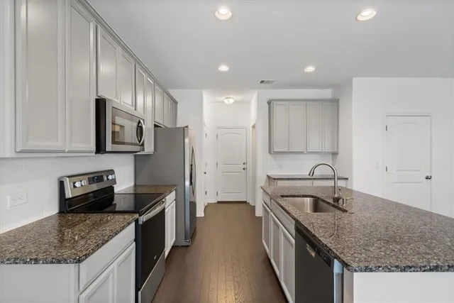 a kitchen with stainless steel appliances granite countertop a sink stove and refrigerator