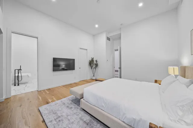 a bedroom with a large bed and a flat screen tv