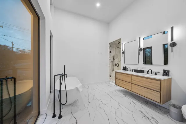 a bathroom with a granite countertop sink a mirror and shower