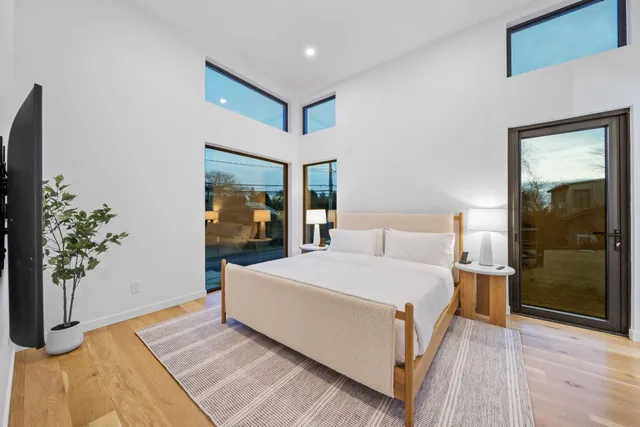 a bedroom with a large bed and a potted plant