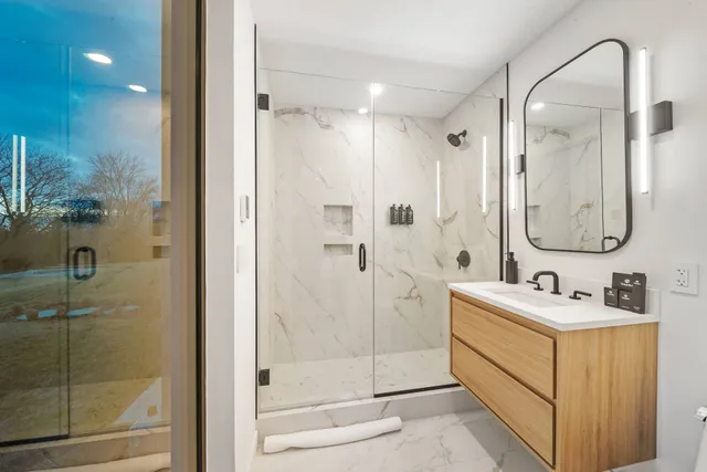a bathroom with a double vanity sink mirror and shower