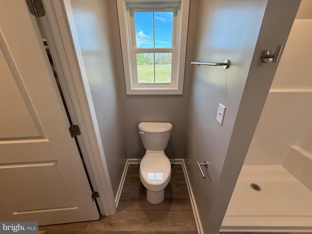 a view of a room with wooden floor and white walls