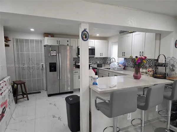 a kitchen with refrigerator and sink