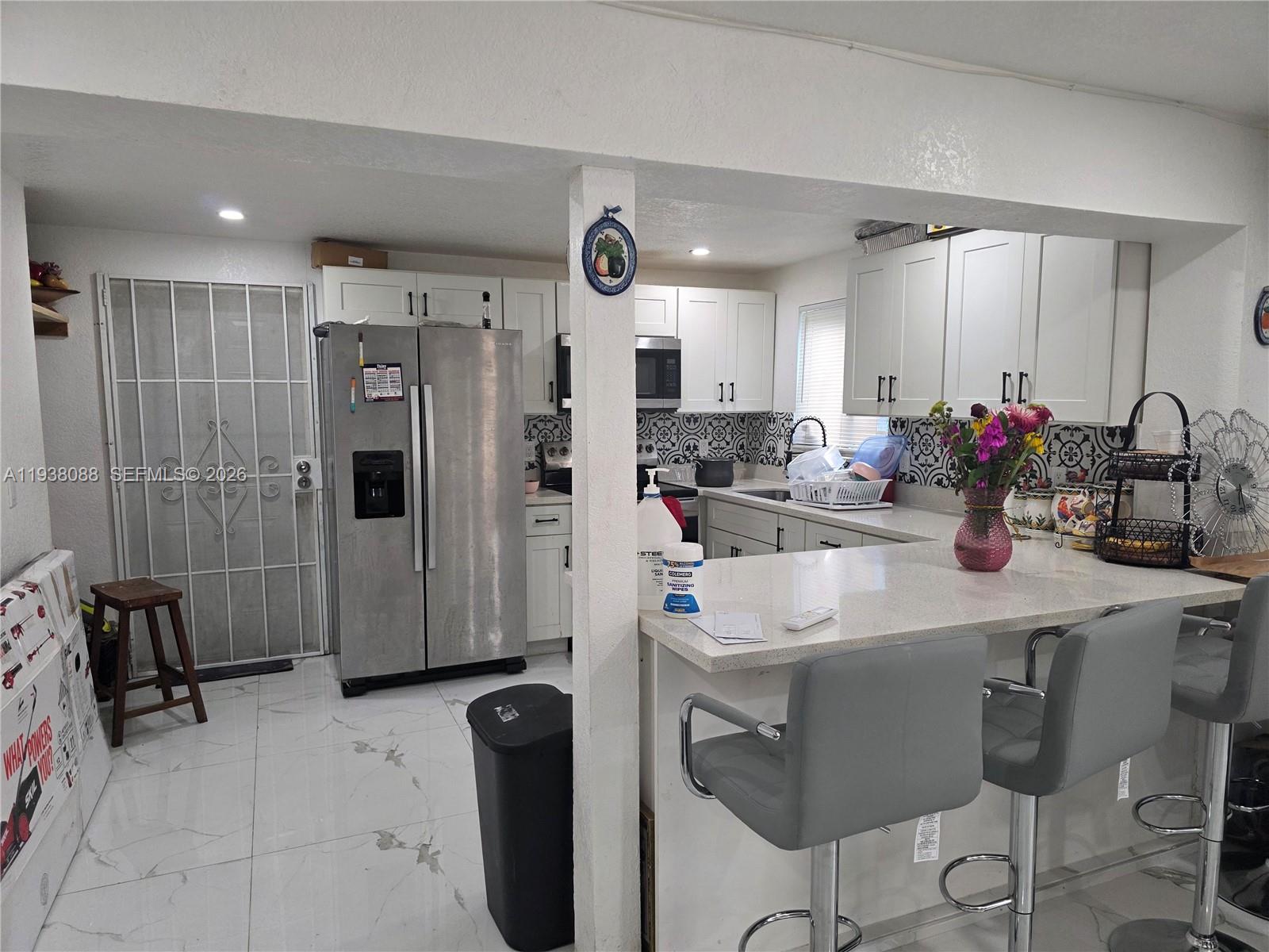 1490 Northeast 147th Street Miami, FL 33161 - Photo 4 of 9 a kitchen with refrigerator and sink