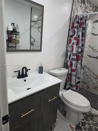 a bathroom with a sink mirror vanity and toilet