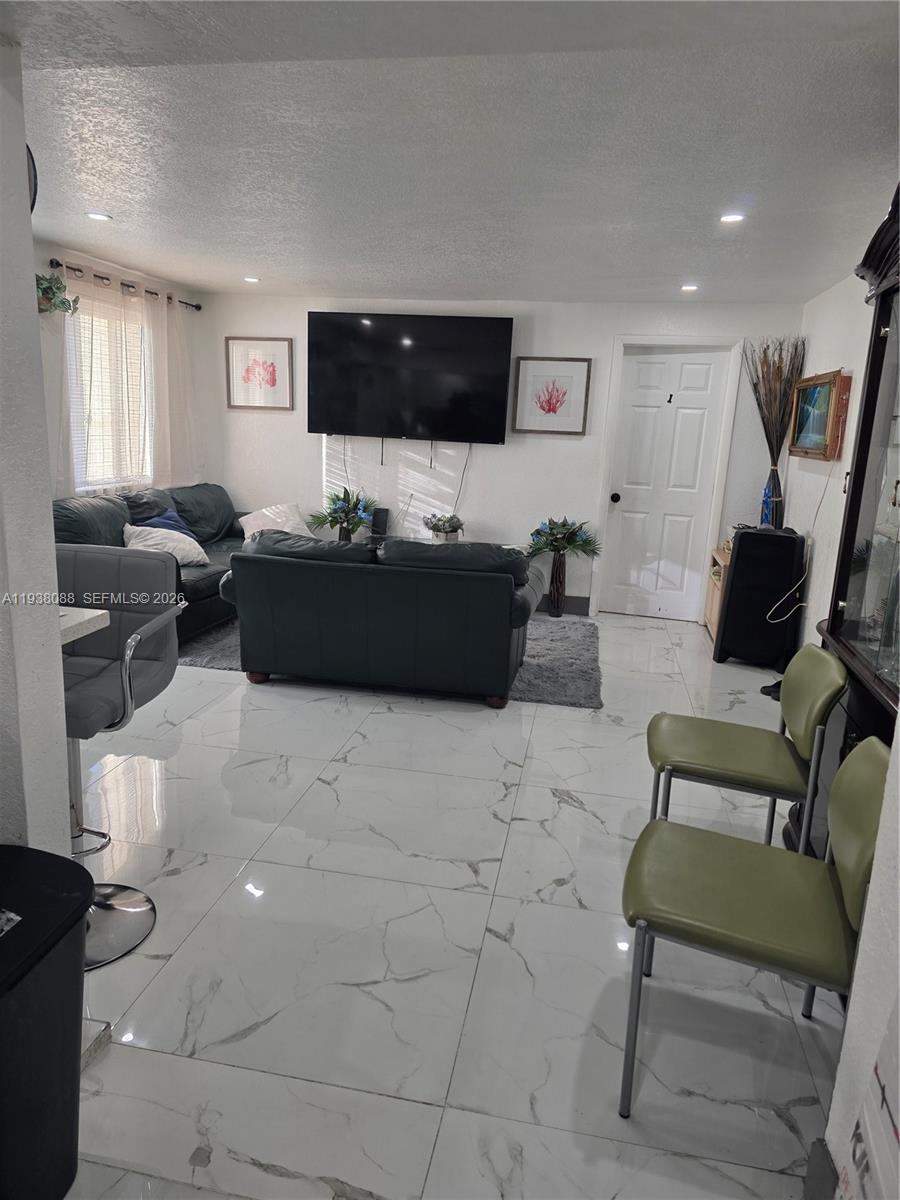 1490 Northeast 147th Street Miami, FL 33161 - Photo 9 of 9 a living room with furniture and a flat screen tv