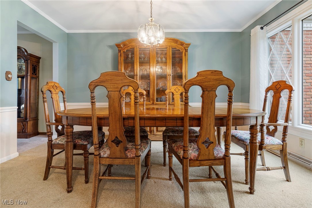 14265 Reeder Avenue Northeast Alliance, OH 44601 - Photo 6 of 39 Dining space with plenty of natural light, light colored carpet, a chandelier, and crown molding