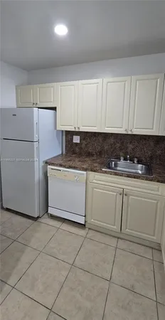a kitchen with cabinets and white appliances