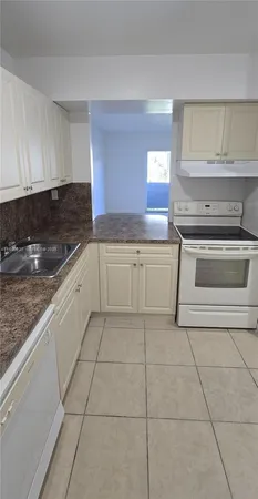 a kitchen with a stove a sink and a counter top space