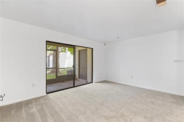 an empty room with sliding glass door and shower