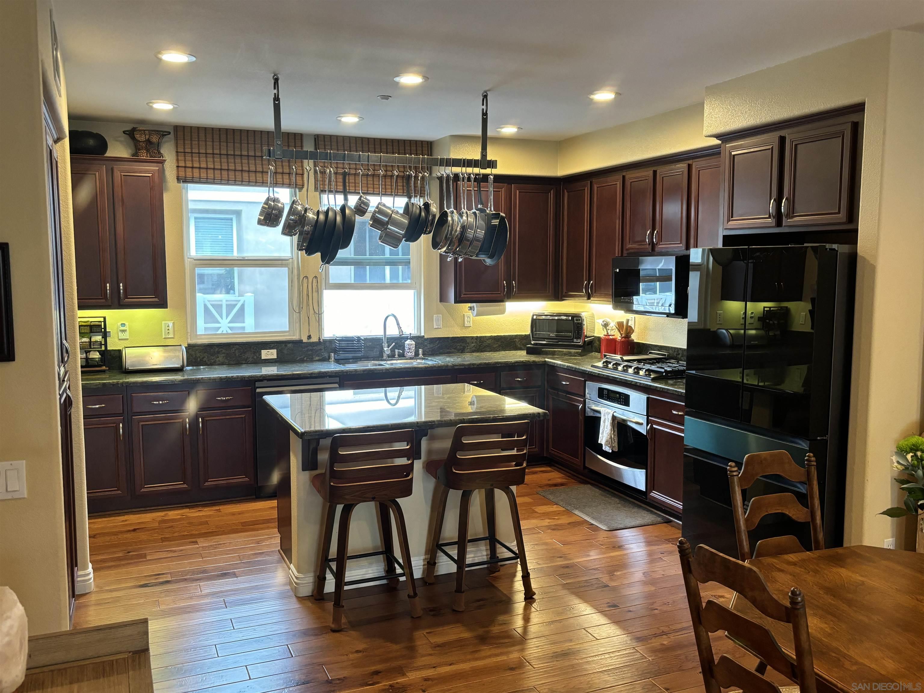 a kitchen with a table chairs refrigerator microwave and cabinets
