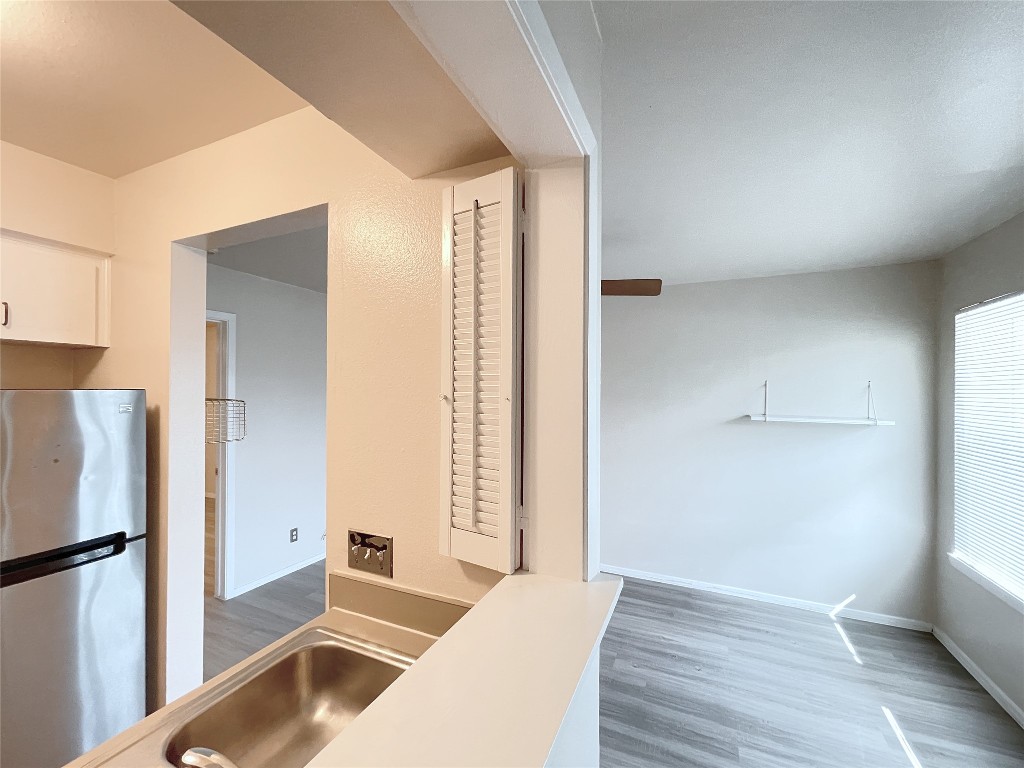 3400 Speedway, Unit 105 Austin, TX 78705 - Photo 5 of 18 a view of a kitchen with wooden floor and a refrigerator