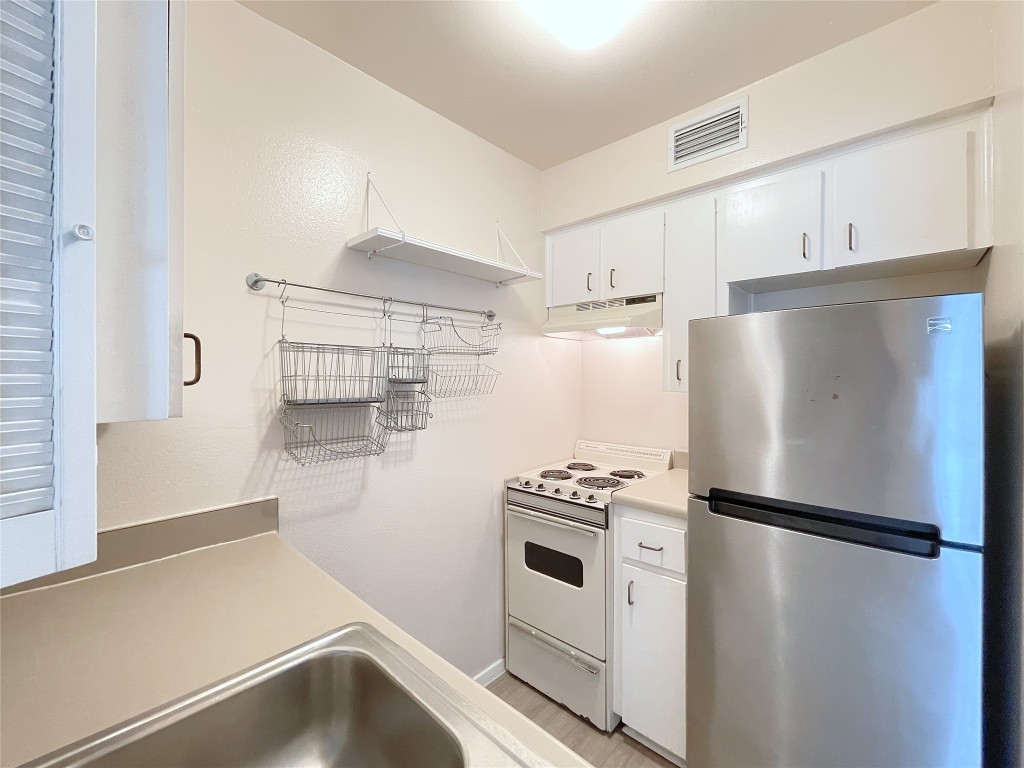 3400 Speedway, Unit 105 Austin, TX 78705 - Photo 6 of 18 a white refrigerator freezer and a stove sitting inside of a kitchen