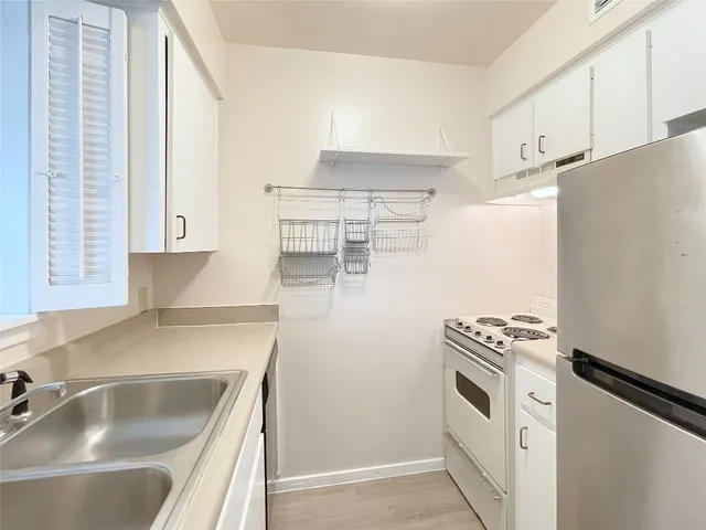 a kitchen with white cabinets and white appliances