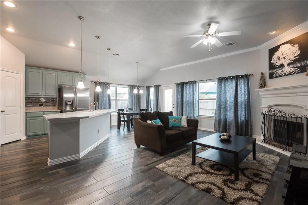 227 Timber Drive Princeton, TX 75407 - Photo 12 of 13 Living area with lofted ceiling, dark wood-type flooring, plenty of natural light, a fireplace, and a ceiling fan