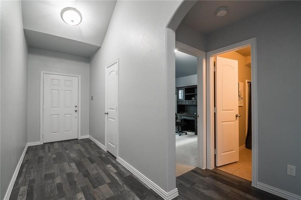 227 Timber Drive Princeton, TX 75407 - Photo 6 of 13 Corridor with arched walkways and dark wood finished floors