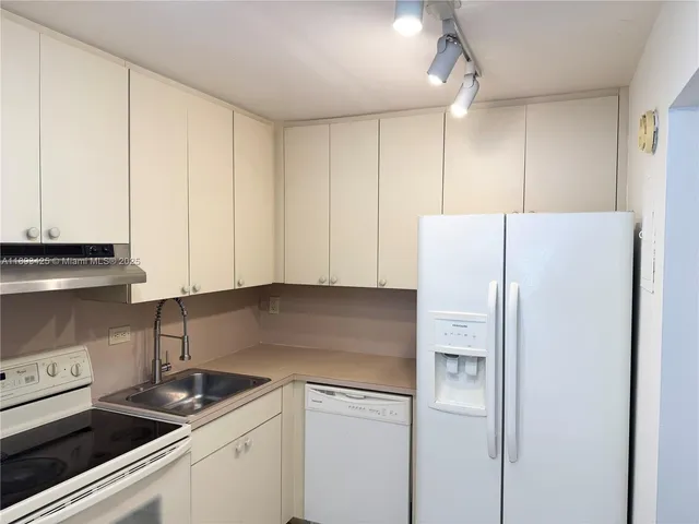 a kitchen with a white cabinets and white appliances