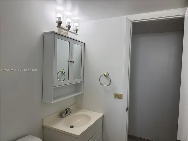 a bathroom with a sink mirror and vanity