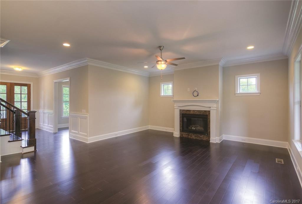 160 Forsythia Lane, Unit 739 Tega Cay, SC 29708 - Photo 5 of 24 an empty room with wooden floor fireplace and mountain view