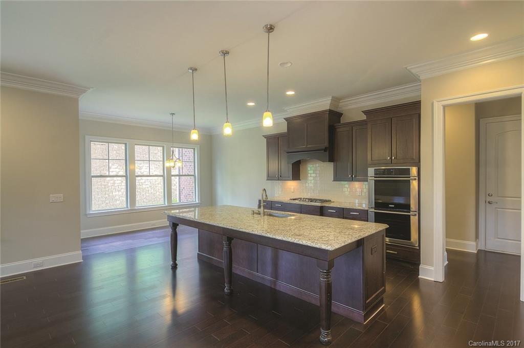 160 Forsythia Lane, Unit 739 Tega Cay, SC 29708 - Photo 6 of 24 a kitchen with kitchen island a sink appliances and wooden floor