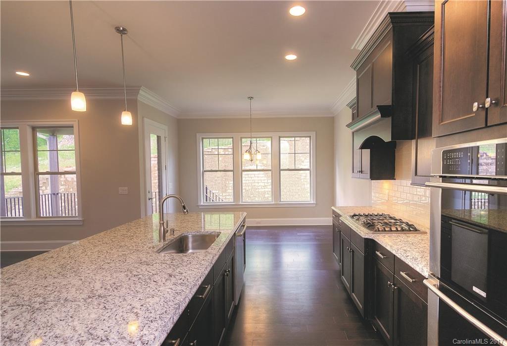 160 Forsythia Lane, Unit 739 Tega Cay, SC 29708 - Photo 8 of 24 a kitchen with stainless steel appliances granite countertop a sink a stove and a wooden floors