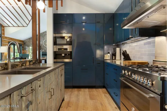 a kitchen with stainless steel appliances a sink stove and cabinets