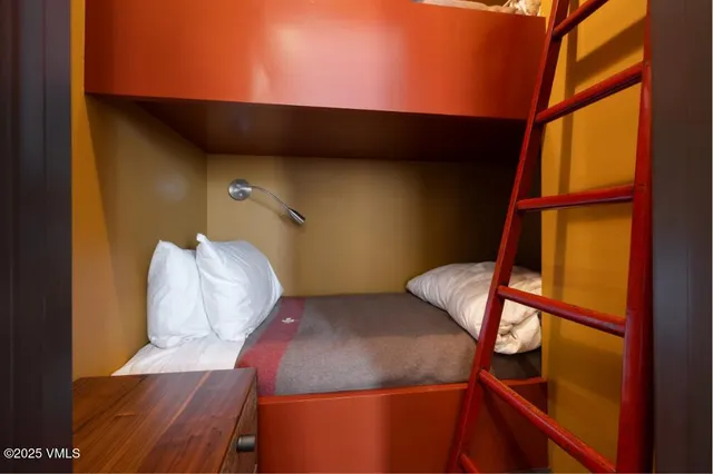 a living room with a bed and a painting on the wall