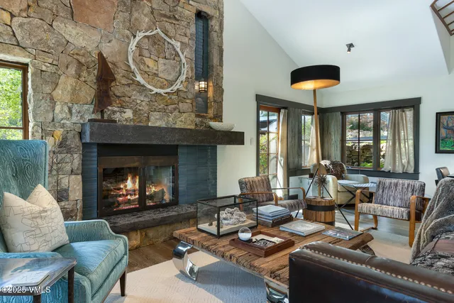 a living room with furniture a fireplace and a large window