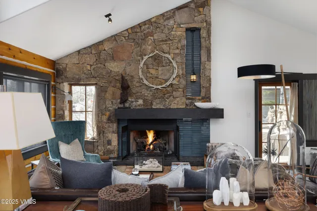 a living room with furniture a fireplace and a large mirror