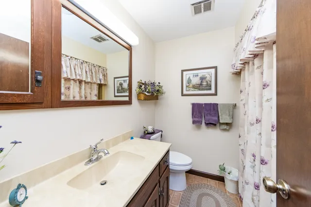 a bathroom with a sink mirror and toilet