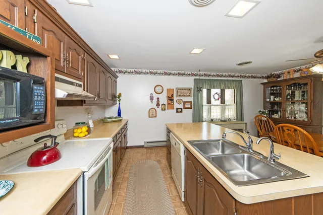 a kitchen that has a sink a stove and a wooden floor