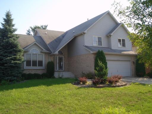 a front view of a house with a garden and plants