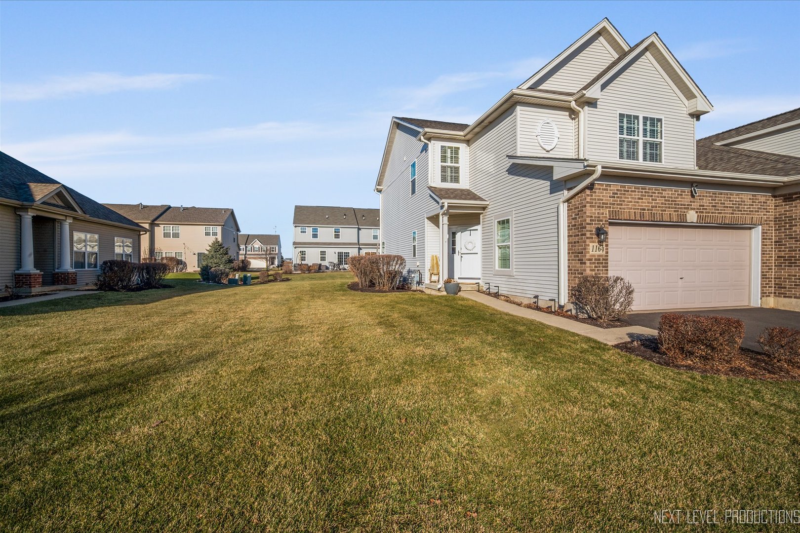 a view of residential houses with yard and car parked
