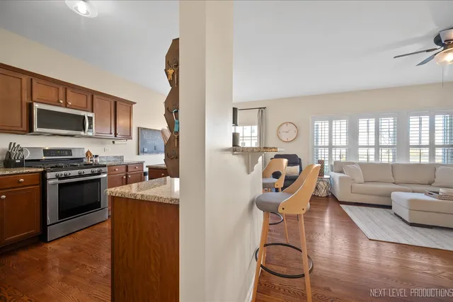 a kitchen with granite countertop a stove top oven a sink a dining table and chairs