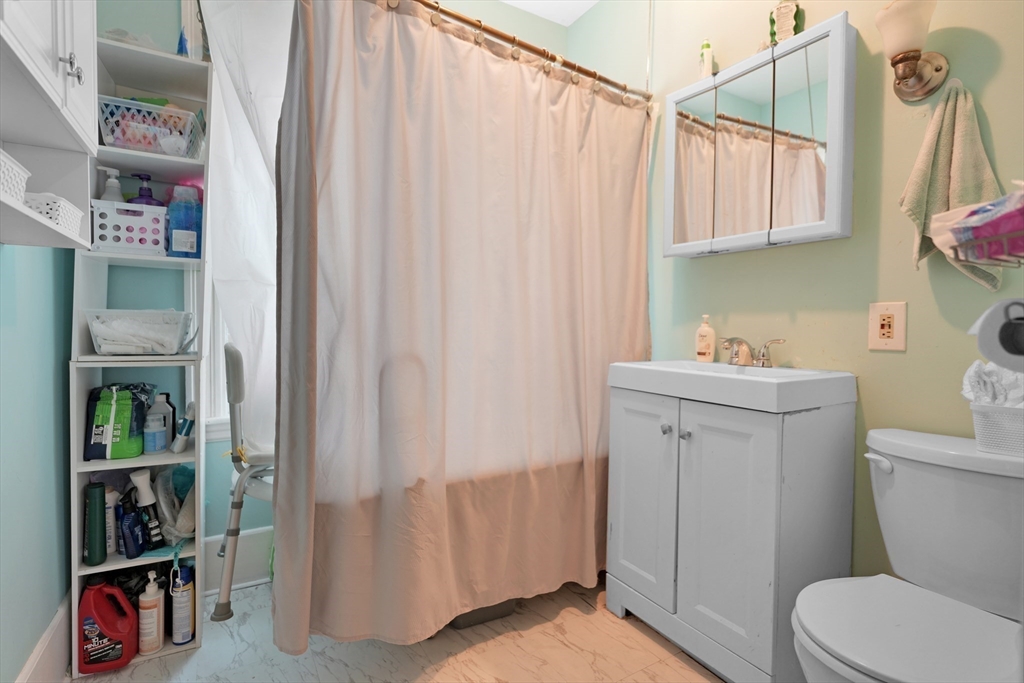 135-137 Query Street New Bedford, MA 02745 - Photo 11 of 17 a bathroom with a sink a toilet and a shower curtain