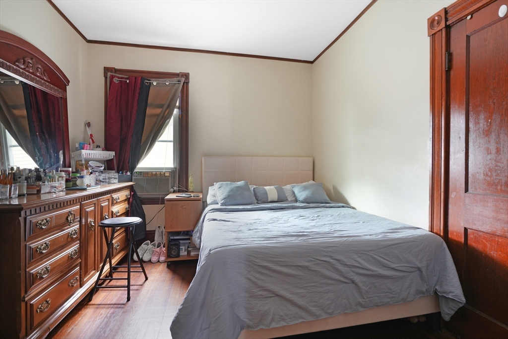 135-137 Query Street New Bedford, MA 02745 - Photo 3 of 17 a bedroom with a bed and a dresser next to a window