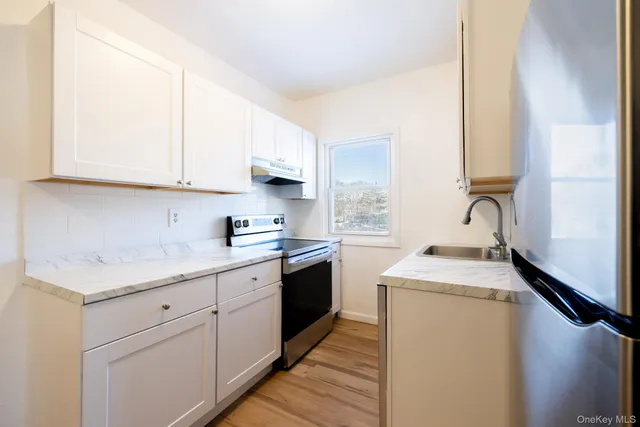 a kitchen with granite countertop white cabinets and white appliances
