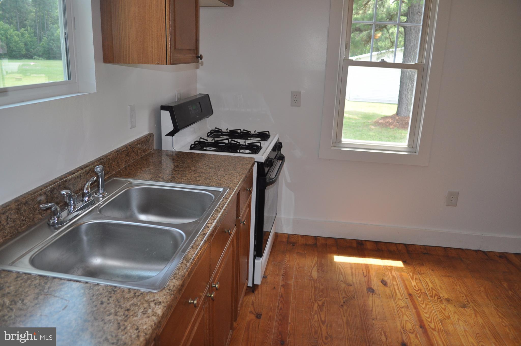 2263 Pomona Road Colonial Beach, VA 22443 - Photo 15 of 28 a kitchen with granite countertop a sink a stove and wooden floor