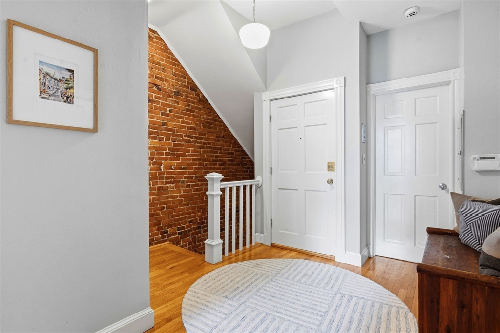 35 High Street, Unit 1 Boston, MA 02129 - Photo 14 of 33 a bedroom with a bed and a bookshelf with wooden floor