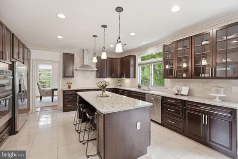 a kitchen with a sink center island cabinets and stainless steel appliances
