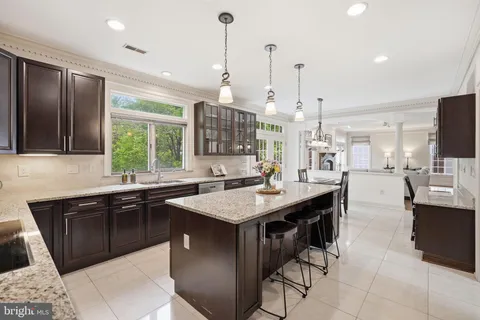 a kitchen with stainless steel appliances granite countertop a sink a stove and a wooden floors