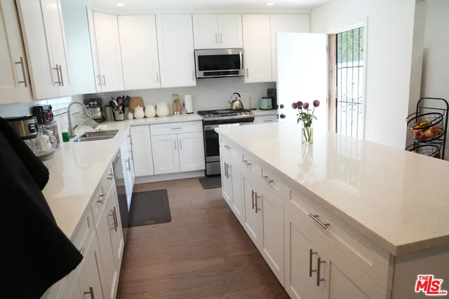 a kitchen with white cabinets sink and white appliances