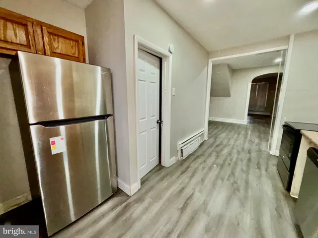 a view of a kitchen with wooden floor and a refrigerator