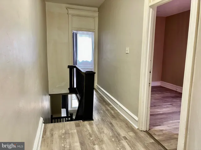 a view of a hallway with wooden floor and staircase