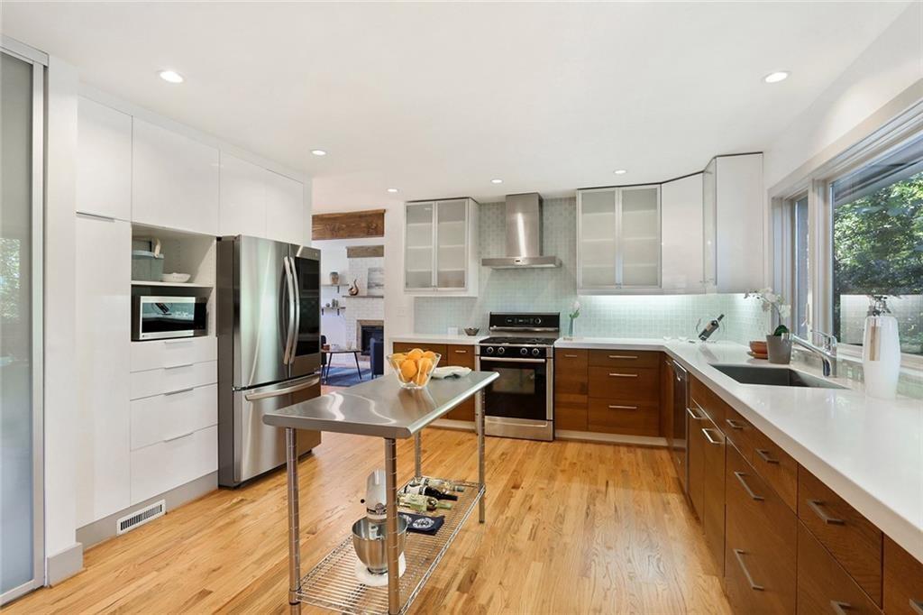 1995 Commodore Lane Atlanta, GA 30341 - Photo 26 of 32 a kitchen with stainless steel appliances a stove a sink a refrigerator white cabinets and wooden floor